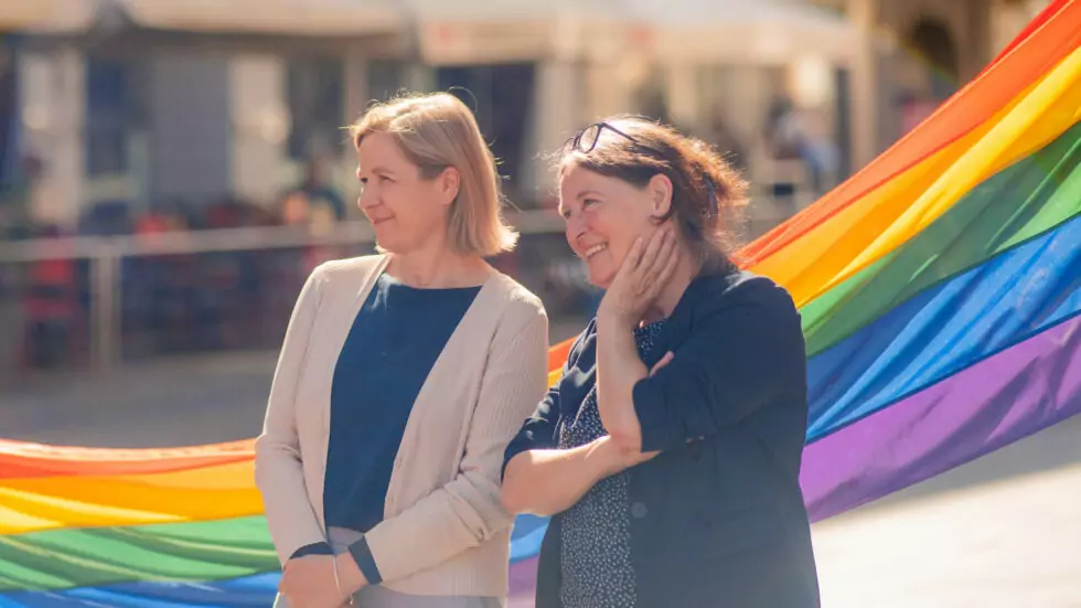 Das Bild auf 5min.at zeigt Judith Schwentner und Elke Kahr vor Regenbogenflaggen.