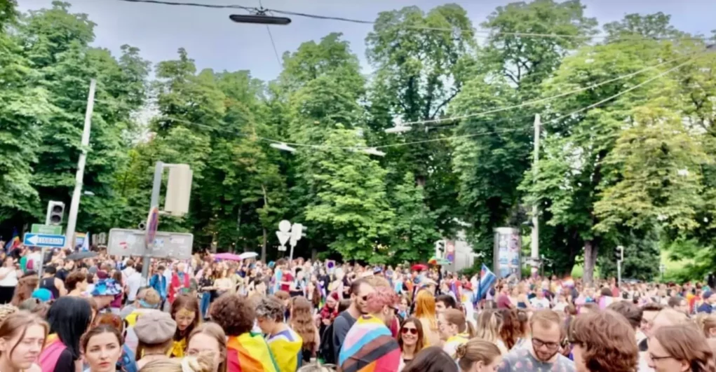 Bild auf 5min.at zeigt die CSD-Parade in graz. Es sind mehrere Personen mit Regenbogenfahnen zu sehen.