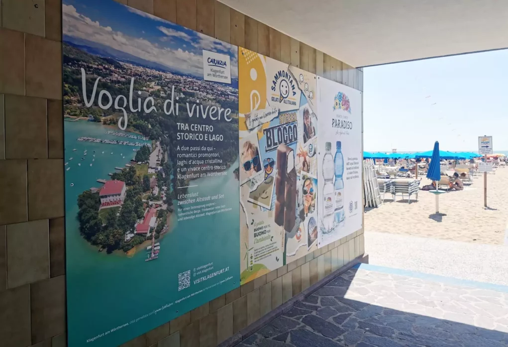 Ein Bild auf 5min.at zeigt ein Klagenfurt-Plakat am Strandeingang in Lignano.