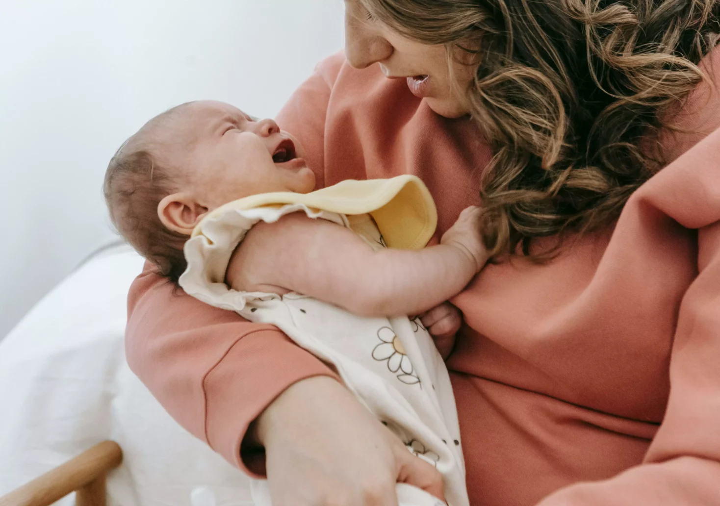 Bild auf 5min.at zeigt eine Mutter mit einem weinenden Baby im Arm.